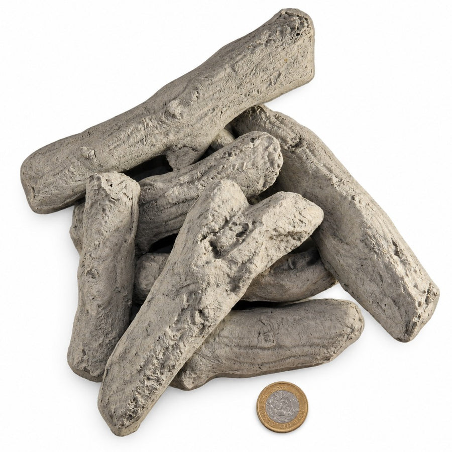 8 Piece Driftwood ceramic gas fire log set piled on a white background with a £1 coin for scale